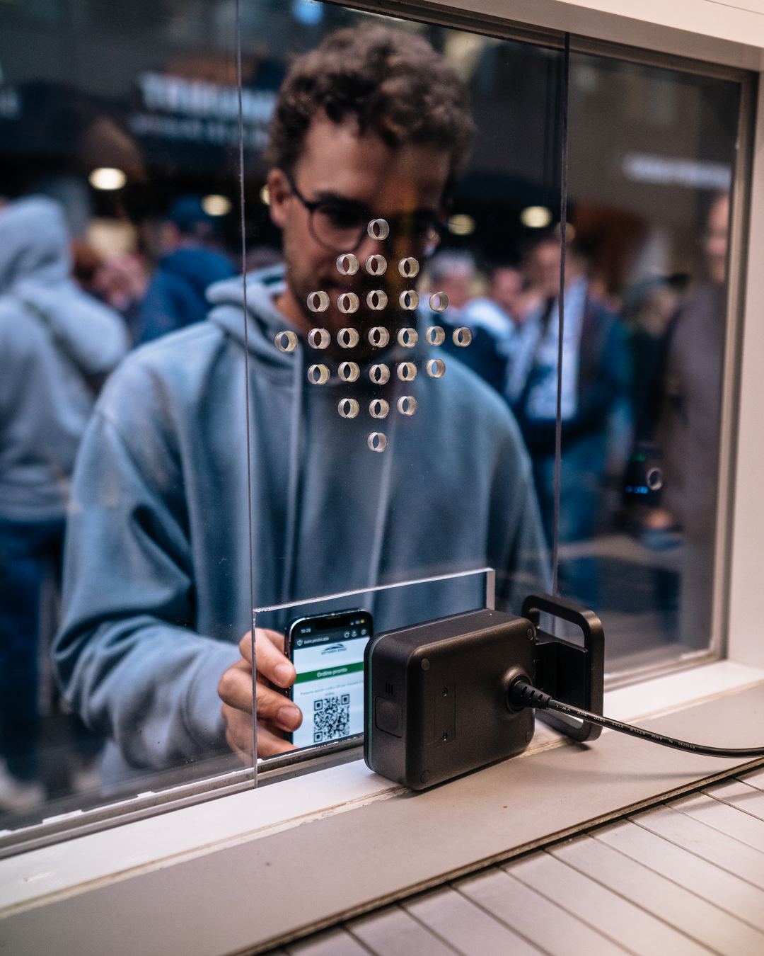 Ein Zahlterminal am Serviceschalter, davor ein Handy.